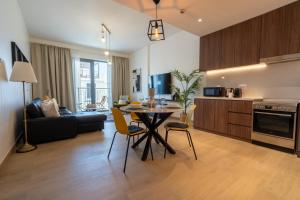 een keuken en een woonkamer met een tafel en stoelen bij HiGuests - Stylish Waterfront Retreat With Balcony in La Mer in Dubai