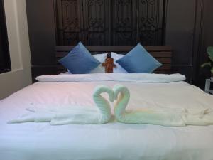 dois cisnes feitos de toalhas numa cama em Nimman 9 em Chiang Mai