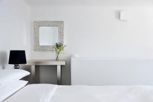 フィロステファニにあるBelvedere Suitesのベッドルーム1室(ベッド2台、鏡付きテーブル付)