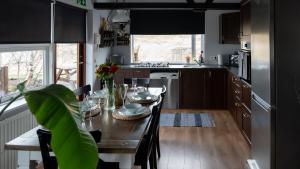 a kitchen with a wooden table and a dining room at Kamburinn Cottage in Hveragerði