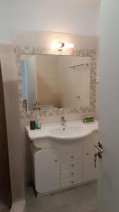 a bathroom with a white sink and a mirror at Sarakiniko in Agiassos +34 photos