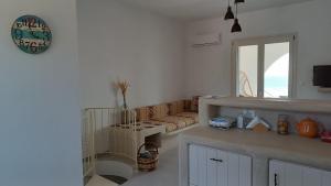 a kitchen with a couch and a clock on the wall at Sarakiniko in Agiassos