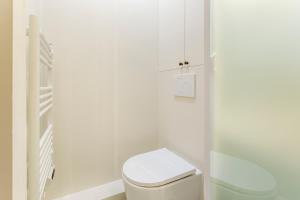 a white bathroom with a toilet and a sink at Habitat Parisien - Bourse Feydeau in Paris +57 photos
