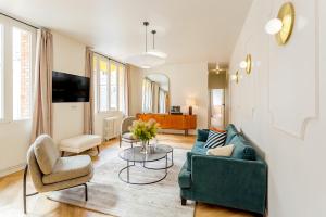 a living room with a green couch and chairs at Habitat Parisien - Bourse Feydeau in Paris