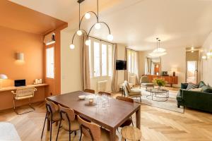 a dining room and living room with a table and chairs at Habitat Parisien - Bourse Feydeau in Paris