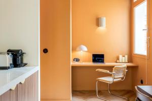 a room with a desk with a chair and a window at Habitat Parisien - Bourse Feydeau in Paris