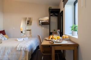una stanza con tavolo con letto e tavolo con cibo di Host Wise - Impressive Restful Houses a Porto