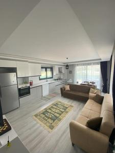 a large living room with a couch and a kitchen at Villa Keyif in Seferihisar
