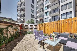 a patio with chairs and a table and a fence at Cozy loft with terrace in the city center in Staré Mesto