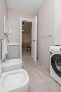 La salle de bains est pourvue de toilettes et d'un lave-linge. dans l'établissement Marina Luxury Apartments Durrës, à Durrës