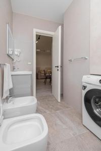 a bathroom with a toilet and a washing machine at Marina Luxury Apartments Durrës in Durrës