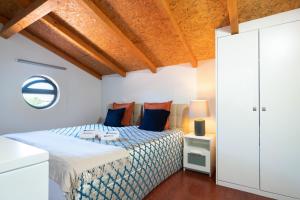 una camera da letto con un letto con cuscini blu e arancioni di Host Wise - Impressive Restful Houses a Porto