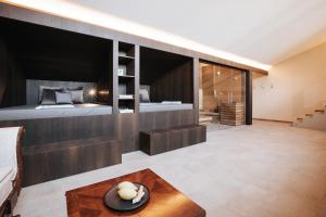 een slaapkamer met een groot bed en een houten muur bij Ansitz Montani Eppan in Appiano sulla Strada del Vino