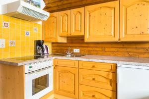 cocina con armarios de madera y horno de fogón blanco en Lenzbauer, en Lessach