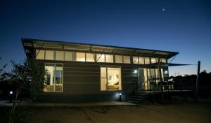 a small house with a lit up window at night at Savannah Cabins, Taronga Western Plains Zoo in Dubbo