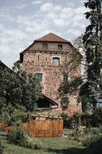 un vieux bâtiment en briques avec une fenêtre au-dessus dans l'établissement Ansitz Montani Eppan, à Appiano sulla Strada del Vino