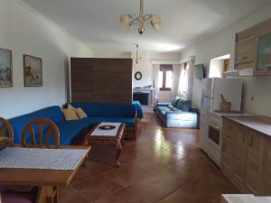 a living room with a blue couch and a kitchen at Garden House KRISTI in Possidi +27 photos