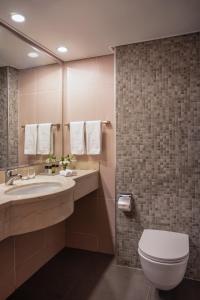 a bathroom with a toilet and a sink at Dan Panorama Eilat in Eilat