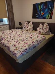 a bed with a floral comforter and pillows on it at Tapas restaurante 1 in Viersen