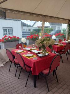 einen Tisch mit roten Tischdecken und Stühlen auf einer Terrasse in der Unterkunft Tapas restaurante 1 in Viersen