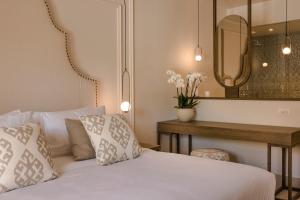 a bedroom with a bed and a table with a mirror at Thalassa Boutique Hotel - Adults Only in Lassi