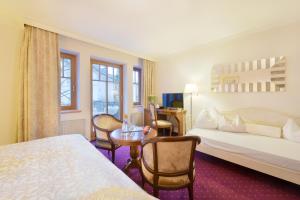 Una habitación de hotel con una cama, una mesa y sillas. en Cella Central Historic Boutique Hotel, en Zell am See