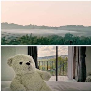 a white teddy bear sitting in front of a window at นอน นี่ นะ โฮสเทล Noen nee Na Hostel in Ban Non Na Yao