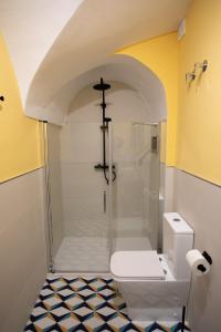 a bathroom with a shower and a white toilet at Apartamento Baluarte de los Pozos in Cáceres