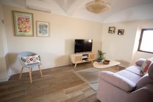 uma sala de estar com um sofá e uma televisão em Apartamento Baluarte de los Pozos em Cáceres