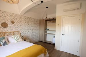 sypialnia z łóżkiem z żółtym kocem w obiekcie Apartamento Baluarte de los Pozos w mieście Cáceres