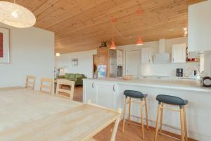 uma cozinha e sala de jantar com tecto em madeira em Nordic Serenity - Amazing Sea And Mountain View 