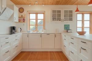 a kitchen with white cabinets and a wooden ceiling at Nordic Serenity - Amazing Sea And Mountain View 