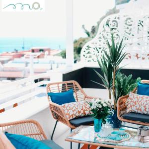patio z krzesłami i stołem z niebieskimi poduszkami w obiekcie AMAREA Exclusive Suites w mieście San Felice Circeo