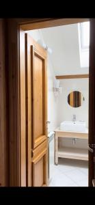 a bathroom with a sink and a wooden door at Pensiunea Tohanu Vechi in Zărneşti