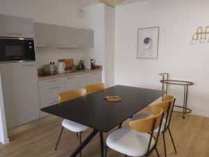 a kitchen with a black table and chairs in a room at CAZAM VERNON-GIVERNY in Vernon