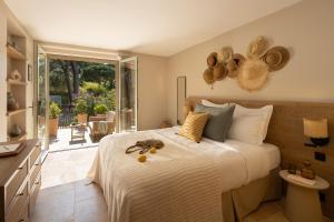 a bedroom with a large bed with hats on the wall at Hôtel L'Escalet in Ramatuelle