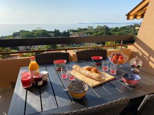 einen Tisch mit Speisen und Getränken auf dem Balkon in der Unterkunft T2 vue mer à Saint-Clair in Le Lavandou