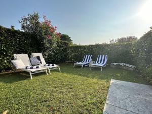 3 chaises bleues et blanches assises dans une cour dans l'établissement Gioia Home, à Bardolino