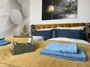 Un dormitorio con una cama con almohadas azules. en Jázmin Apartman en Sárvár
