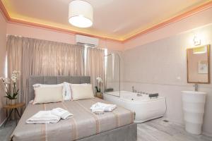 1 dormitorio con cama, bañera y lavamanos en Ex Animo - Luxury Apartments en Zakynthos