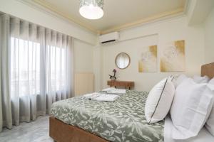 una camera da letto con un grande letto con cuscini bianchi di Ex Animo - Luxury Apartments a Città di Zante