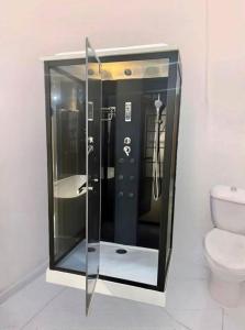a glass shower in a bathroom with a toilet at SkyLight Residence in Yaoundé