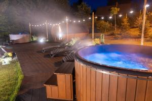 a large hot tub in a park at night at Srebrny Bucznik Wellness & Restaurant in Istebna
