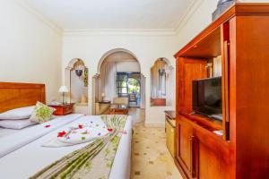 een slaapkamer met een bed en een flatscreen-tv bij Ghazala Gardens in Sharm El Sheikh