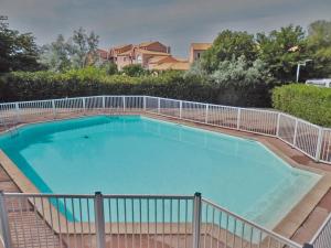 ein großer Pool mit einem Zaun um ihn herum in der Unterkunft Lagrange Vacances Le Scarlett et Les Soleillades in Palavas-les-Flots