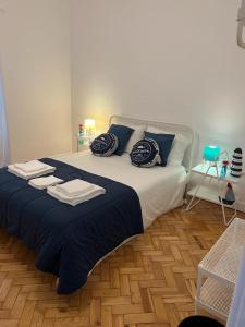 里斯本的住宿－Alvalade II Airport Guest House，一间卧室配有一张大床,提供蓝色的床单和枕头