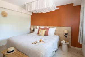 a bedroom with a bed with a tray of food on it at Hôtel L'Escalet in Ramatuelle