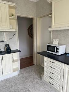 a kitchen with a counter with a microwave on it at Alvalade II Airport Guest House in Lisbon