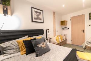 a bedroom with a bed with yellow and black pillows at Luxury Bumblebee Cottage Frome Longleat Aqua Sana Bath DOG FREEndly in Frome