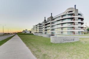 a large apartment building with a sign in front of it at Oceana Suites en Isabel, frente a playa Mansa in Punta del Este